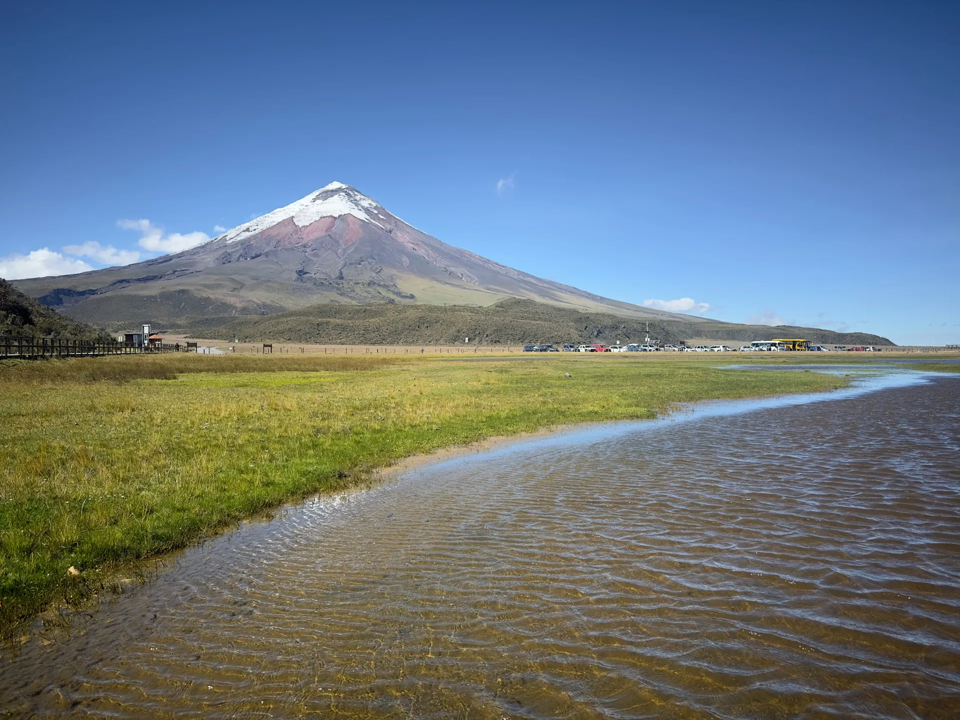 Limpiopungo lagoon wetland with Cotopaxi volcano behind and the park’s car park in the distance