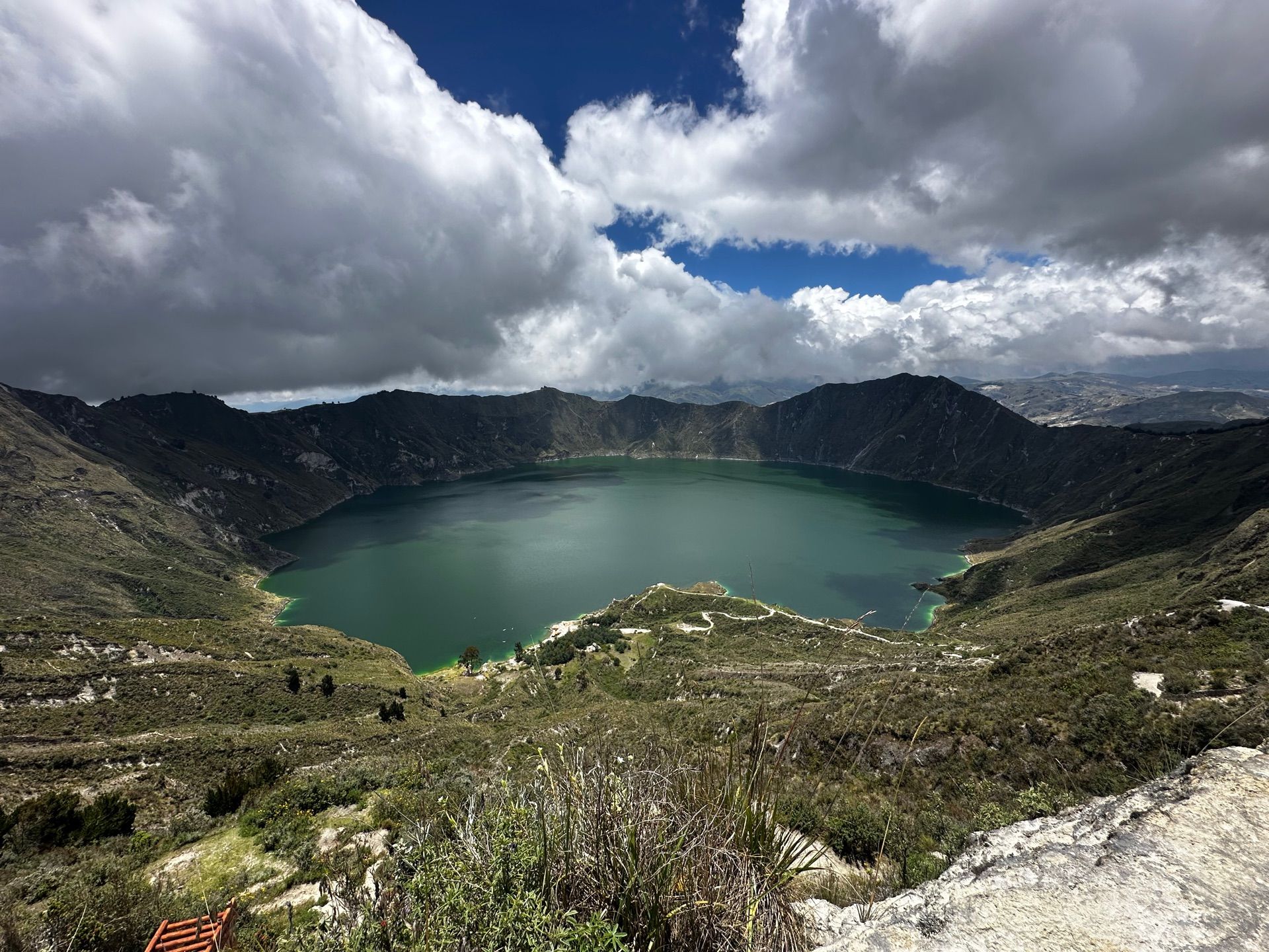 The full crater rim of Quilotoa under dramatic Andean clouds, one of Ecuador's classic hikes